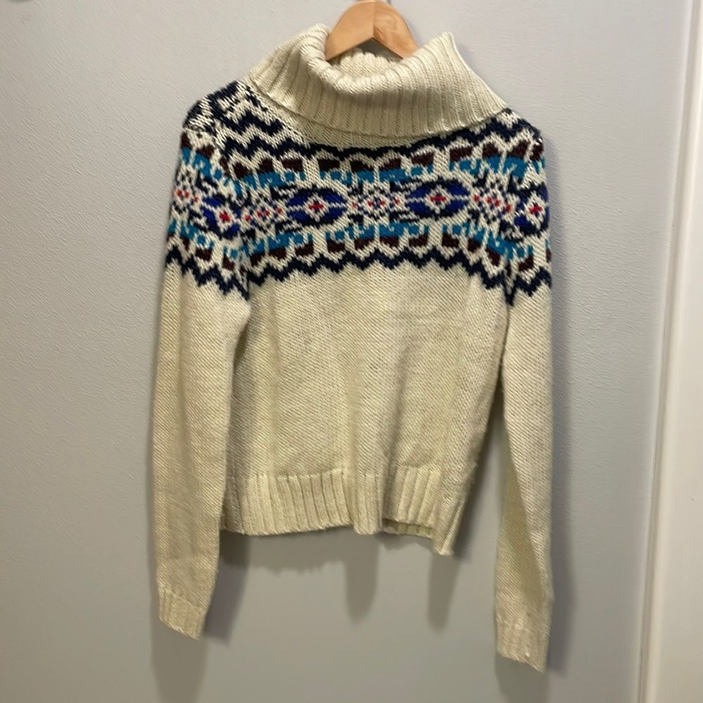 Prince and Fox woman’s cream turtleneck sweater with a colorful design